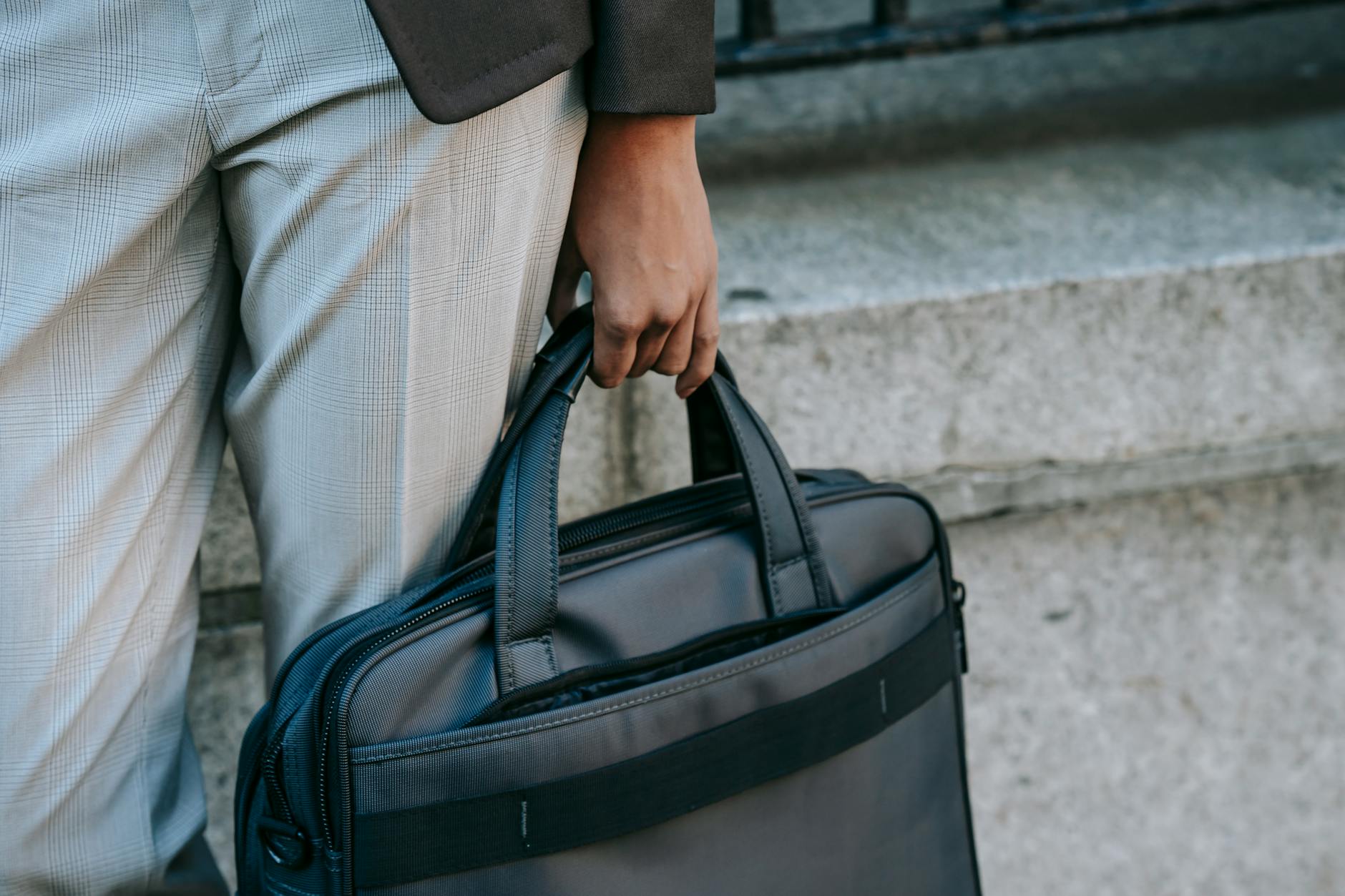 Person Im Grauen Hemd, Das Schwarze Lederhandtasche Trägt