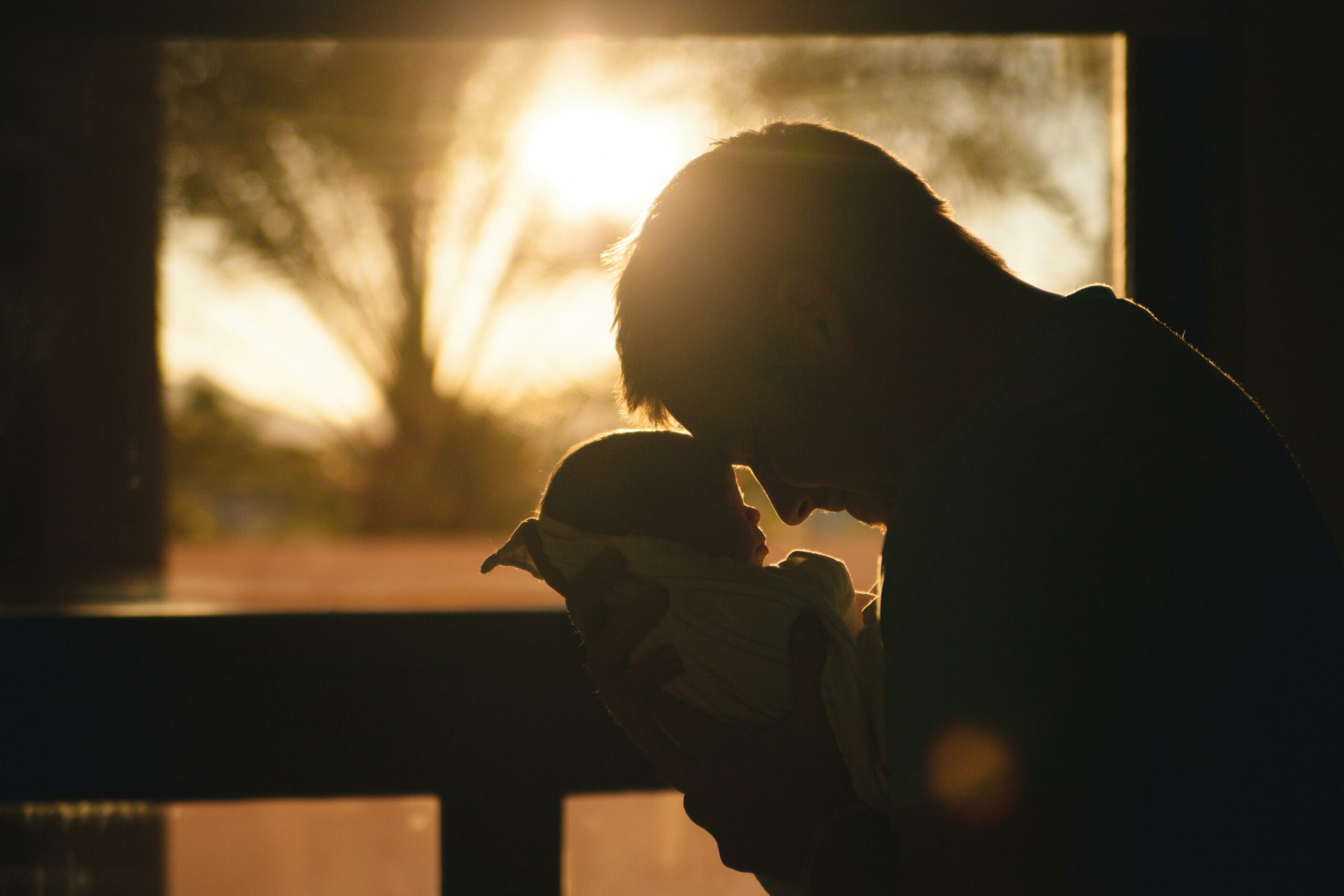 Mann, Der Baby Trägt, Das Ihre Stirn Zeichnet